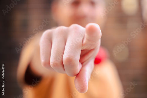 Wallpaper Mural Close-up of a person is hand pointing directly at the camera, with face intentionally blurred in the background, symbolizing selection, focus, choice, accusation, recruitment, or personal attention Torontodigital.ca
