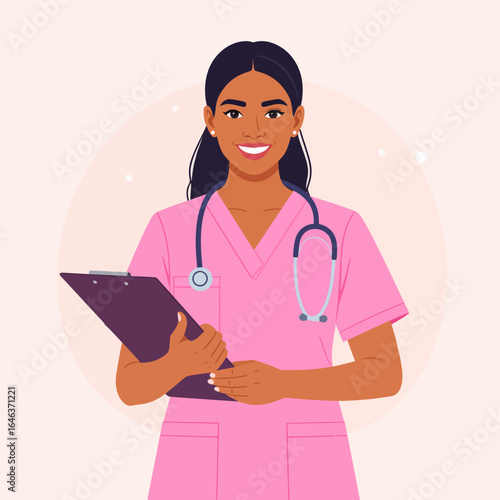 Smiling female nurse with dark hair in pink scrubs, holding a clipboard and wearing a stethoscope.