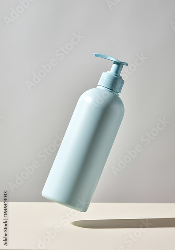 Light-blue pump bottle, levitating, minimalist design.
