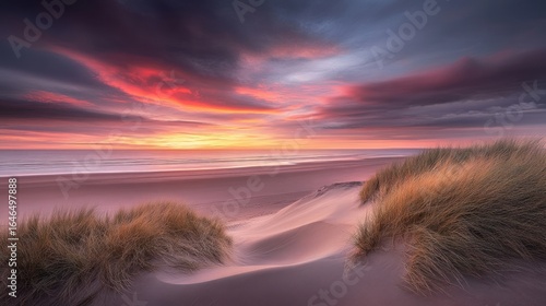 Serene Sunset at the Beach: A breathtaking view of a vibrant sunset over a tranquil beach, dunes, and seagrass, captured at golden hour.