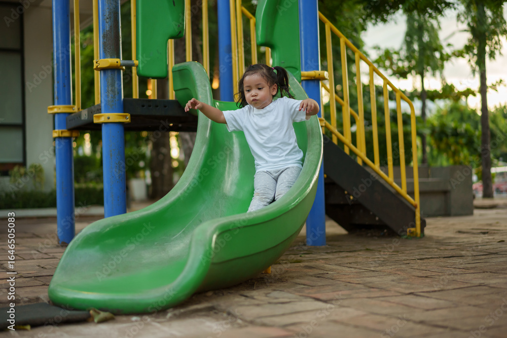 Φωτογραφία happy toddler baby girl sliding and playing at playground