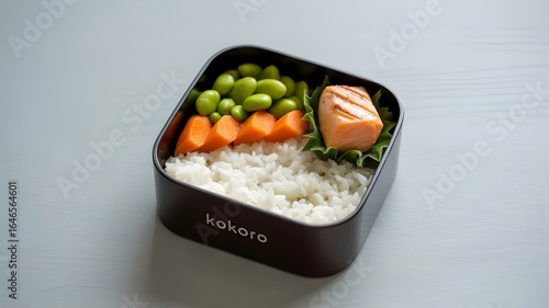 Healthy Japanese Salmon Bento Box Lunch: Grilled Salmon, Edamame, Carrots, and Rice in Stylish Black Container