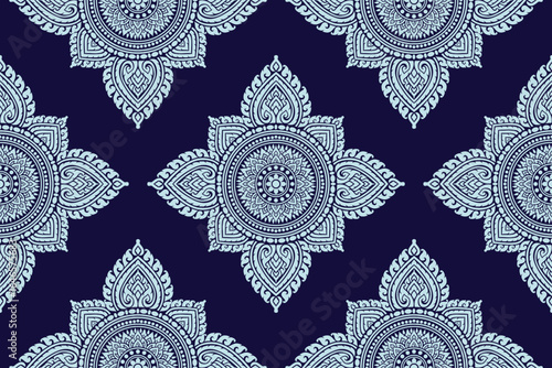 Traditional Thai art seamless floral pattern bold white colored damask style motif suitable for wallpaper, cloth, textile, tile and fabric design isolated over blue background.