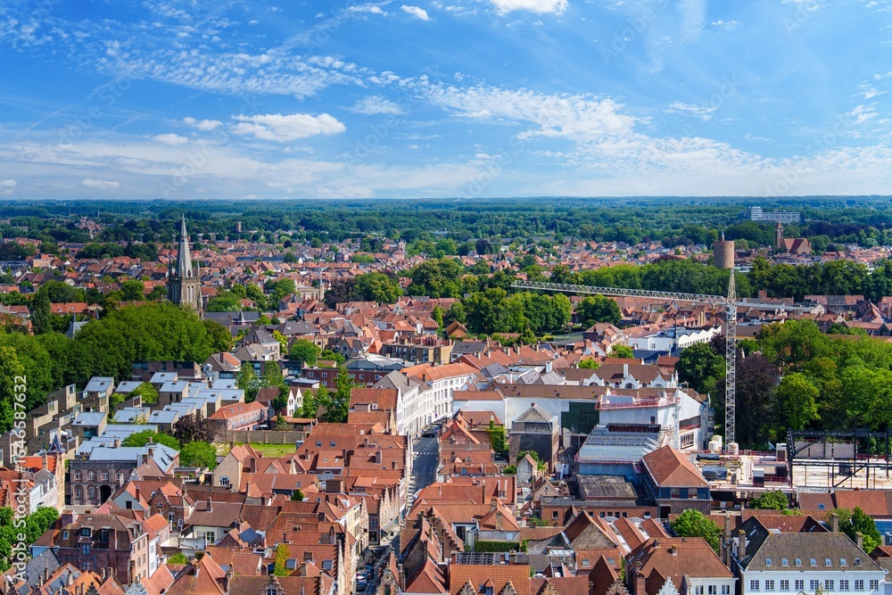 Obraz premium Experience the charm of Brugge, Belgium, with this aerial view of its iconic red-tiled roofs, picturesque canals, and historic landmarks, showcasing the city s rich cultural heritage.