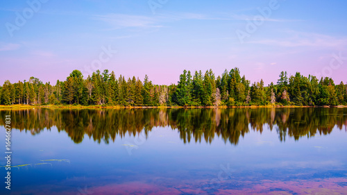 Early autumn sunrise landscape over Flagstaff Lake in Maine with water reflections of the pine forests, a quiet moment in the heart of New England.