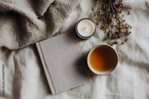 Cozy afternoon with warm tea, a good book, and calming candle creating a peaceful hygge atmosphere for relaxation and self-care
