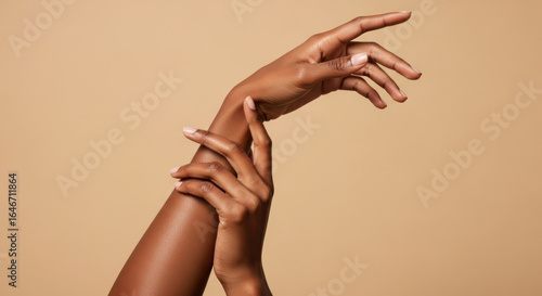 Elegant female hand with smooth dark skin, graceful fingers, and natural nails on beige background, expressing beauty and wellness in minimalistic style