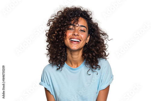 Happy young woman with curly brown hair laughing joyfully. Cheerful and natural female beauty with a genuine smile in a studio shot