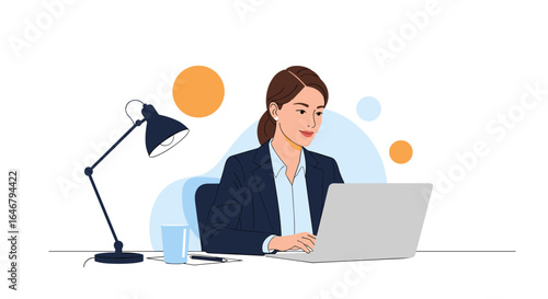 Businesswoman working diligently at her desk with a laptop and desk lamp