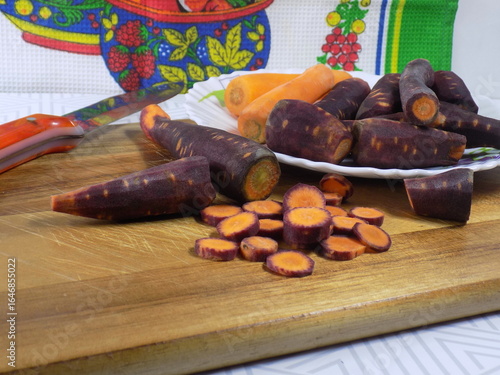 Purple carrots on a plate are sliced for a healthy salad.