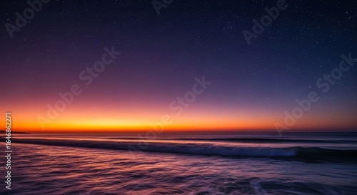 Starry night sky over ocean at vibrant sunset
