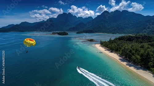 Aerial view of tropical paradise. Paraglider soars over turquoise water, near a white sandy beach
