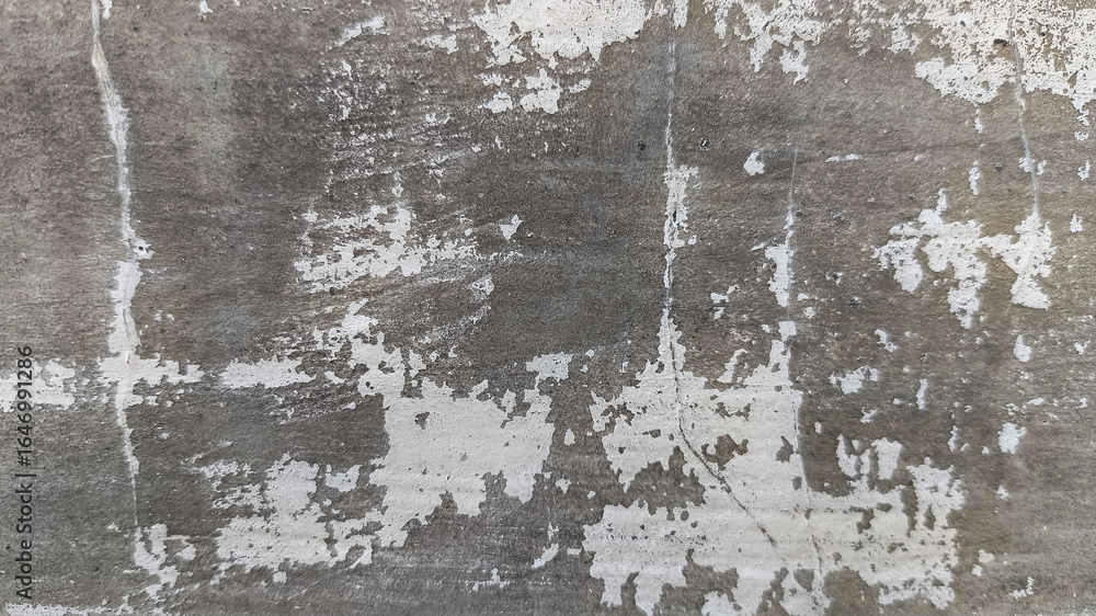 Fototapeta premium Distressed horizontal surface of concrete wall showing scratches, cracks, and worn cement for use in grunge backgrounds, architectural design, or texture archives.