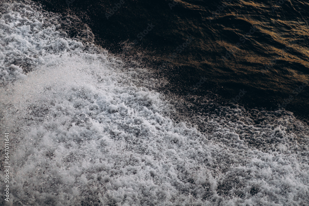 Φωτογραφία A close-up, abstract view of churning sea foam and waves, showing the dynamic texture and movement of the ocean water