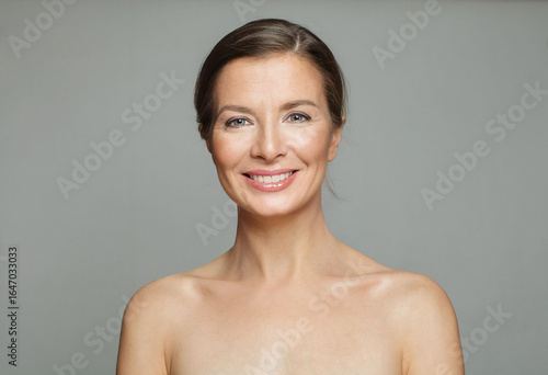 Glorious mid aged mature woman looking at camera and smiling. Healthy face skin care beauty