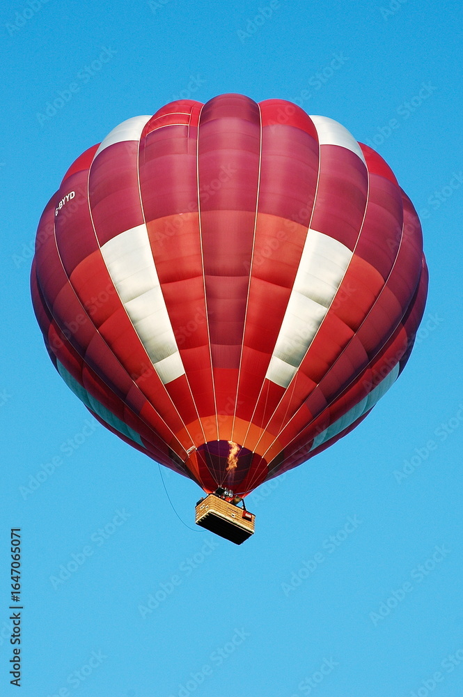 Fototapeta premium A hot air balloon in flight against a clear blue sky.