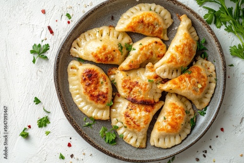 A plate of fried pierogi with parsley garnish close up