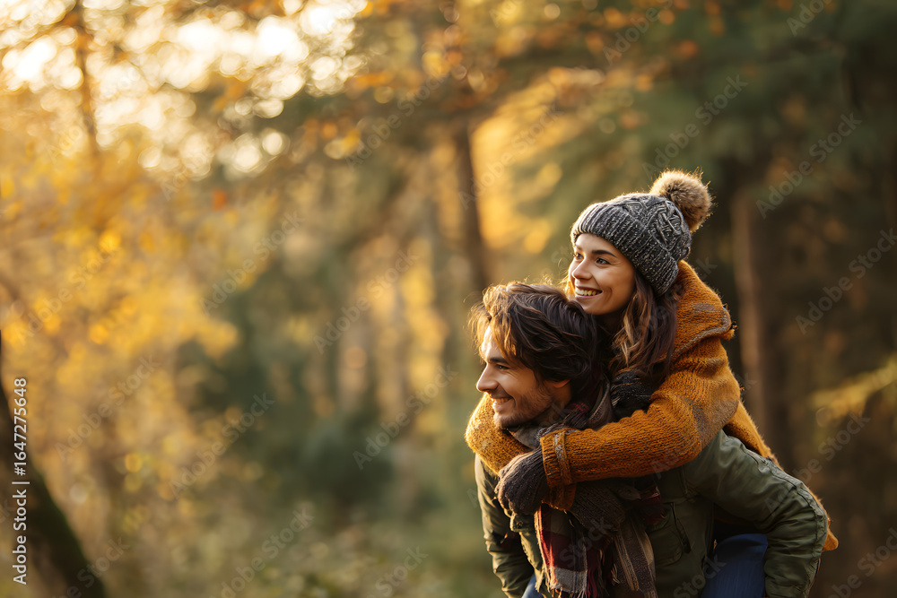 Fototapeta premium Happy couple piggybacking in a forest one autumn afternoon