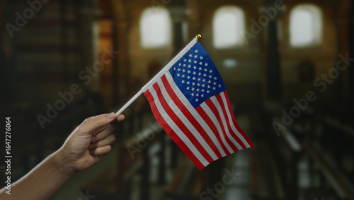 Quadro em tela Caucasian man holding an american flag inside a church, symbolizing patriotism and faith in a serene indoor setting, with focus on the united states national emblem