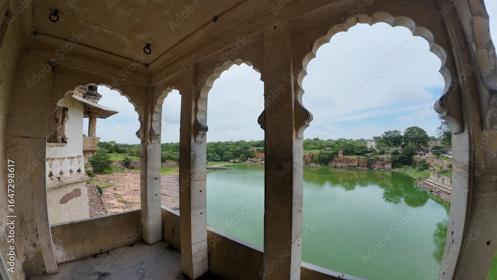 Fototapeta premium Columns and arches of Ratan Singh Palace with a picturesque lake view, set in the Chittorgarh Fort complex