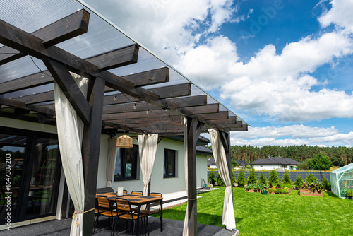 The terrace behind the house is made of beams, the roof is covered with polycarbonate.