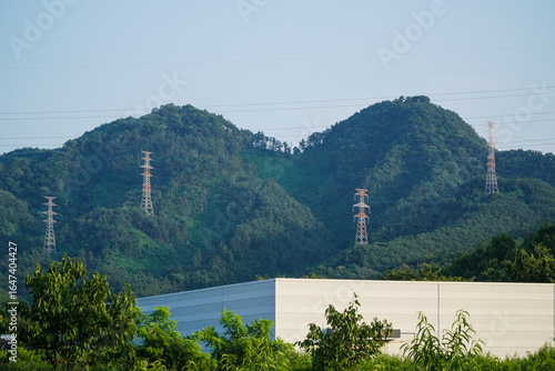 Power Lines and Transmission Towers Over Green Mountains