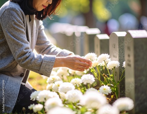墓前で花を添えて手を合わせる
