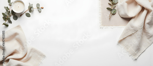 Soft beige textiles and eucalyptus branches on white background