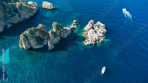 Ripresa dall’alto di costa rocciosa e mare blu con imbarcazioni