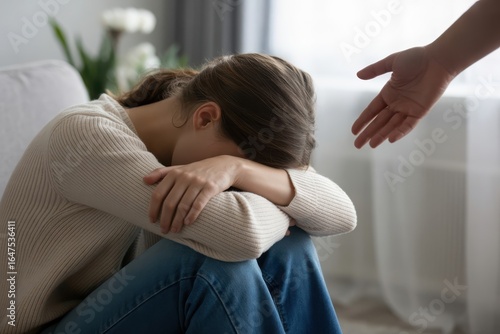 Woman experiencing sadness with a hand reaching out offering support and empathy, mental health concept