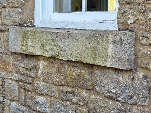 Obraz na plátně Close-up of an old stone windowsill beneath a white wooden-framed window