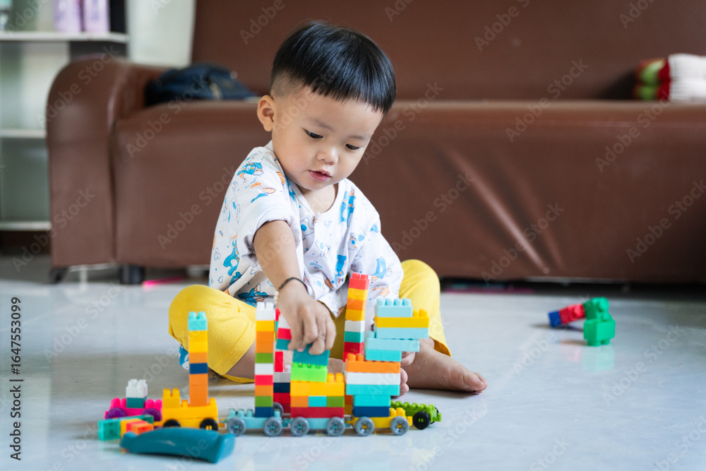 Fototapeta premium Child Playing with Colorful Building Blocks Indoors