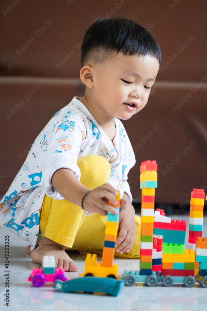 Fototapeta premium Child Playing with Colorful Building Blocks Indoors