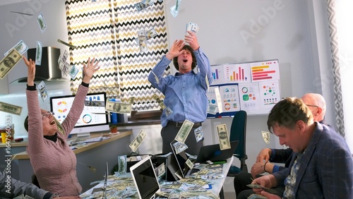 The staff of a financial company scatters all the earned money in a cozy office kitchen. Employees celebrate their promotions. A big lottery win