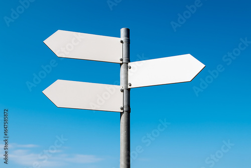 A blank white directional signpost with three arrow-shaped signs, angled in different directions against a clear blue sky. For illustrating choice, direction, decision-making, or travel concepts