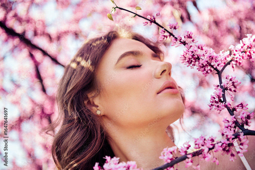 Lovely woman enjoying a sunny day surrounded by blooming pink flowers, expressing serenity and connection with nature. Lovely woman enjoying a sunny day surrounded by blooming pink flowers, expressing serenity and connection with nature.