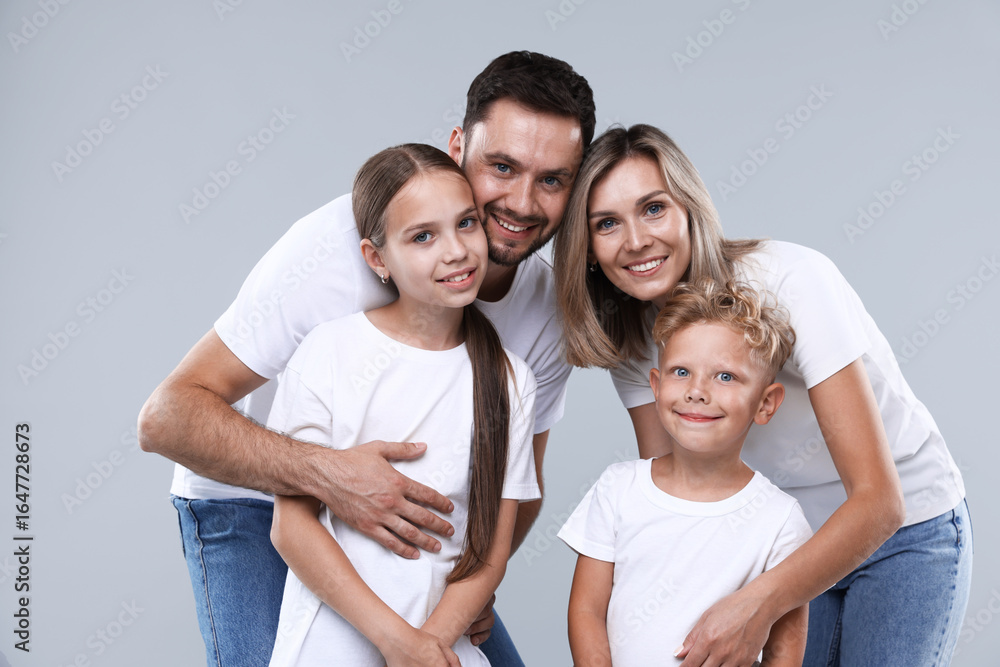 Family portrait of happy parents and their children on grey background Family portrait of happy parents and their children on grey background