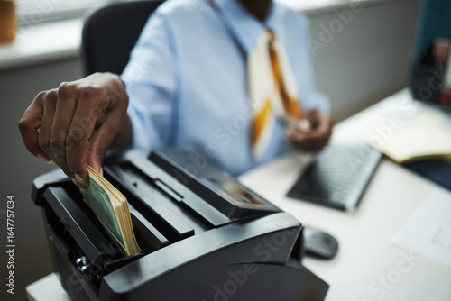 Obraz na plátně Hand of bank worker processing stack of cash using bill counting machine in offi