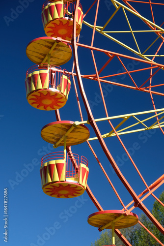 bright yellow-orange ferris wheel against blue sky