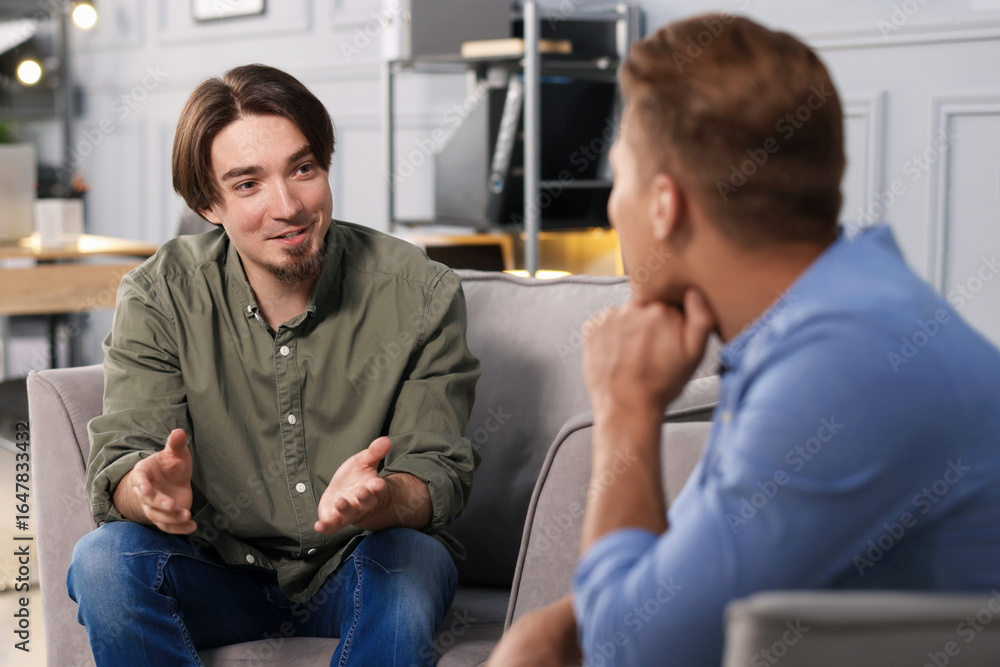 Obraz premium Colleagues having conversation during break in armchairs at office