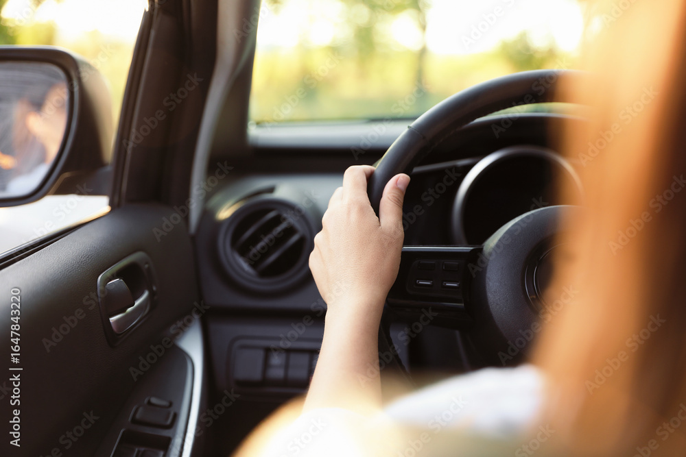 Woman behind steering wheel of modern car, closeup Woman behind steering wheel of modern car, closeup
