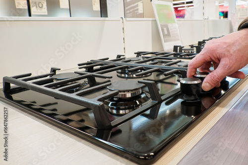 Gas stove. Turning on and off the gas burner. A home appliance store. Consumer