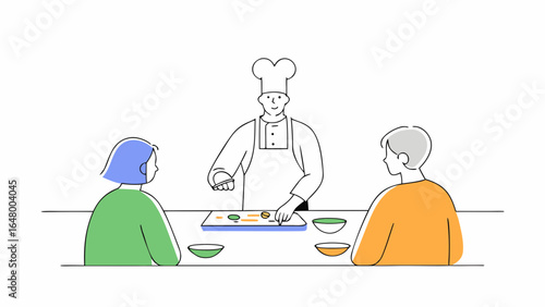 Chef prepares food for two diners at a table.
