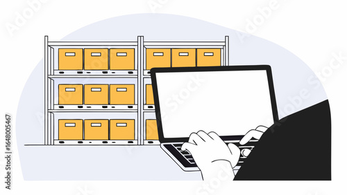 Person working on laptop in a warehouse.
