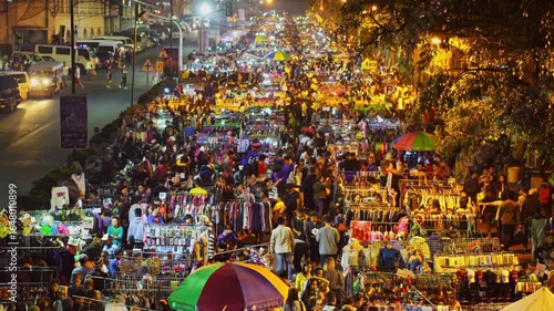 A vibrant night market in india with a large crowd of people shopping
