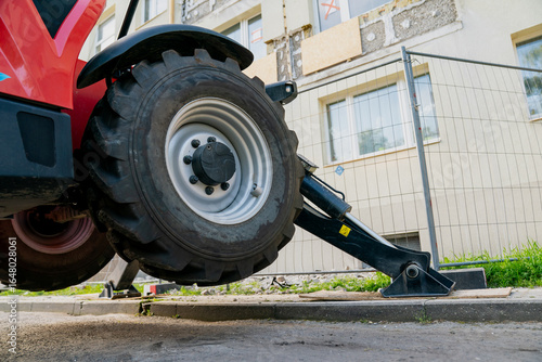 Fotografie Heavy construction machinery stabilizer leg with large wheel lifting on hydrauli