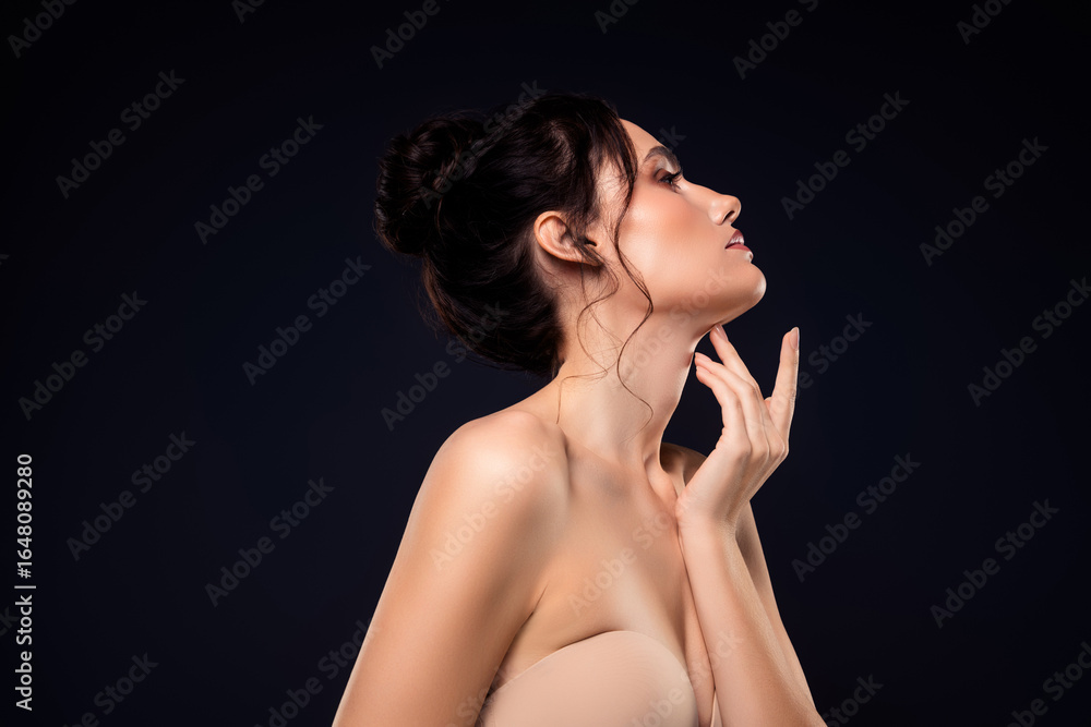 Fototapeta premium Beautiful young brunette woman showing elegance and sensuality with glamorous makeup and hairstyle