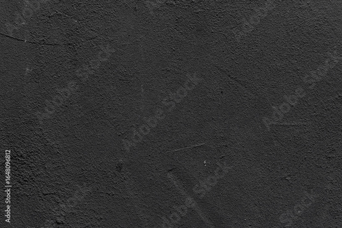 Close-up of aged black wall with cracked paint and worn texture