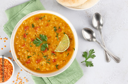 Traditional Indian dal soup with red lentils, spices fresh cilantro on white background. Indian food