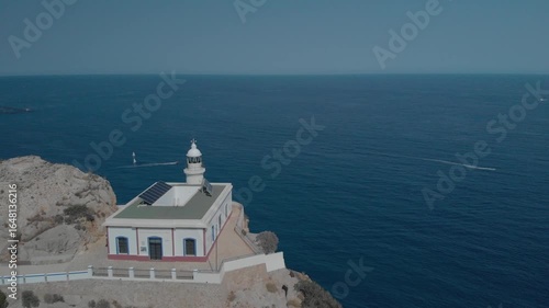 Aerial view of lighthouse with solar panels at coastline in Spain